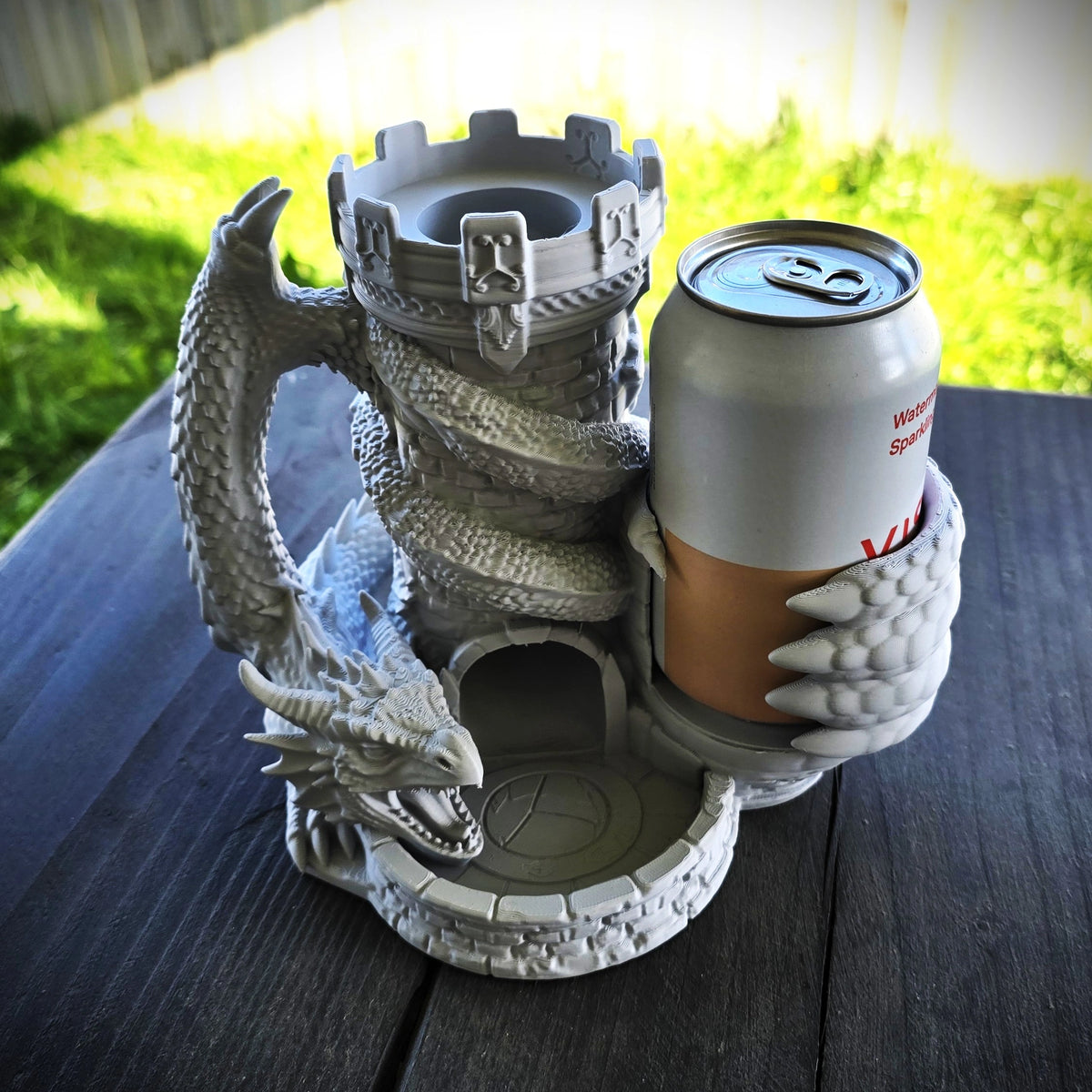 Grey dragon dice tower with integrated can holder, drink can and dice displayed in the front catching tray
